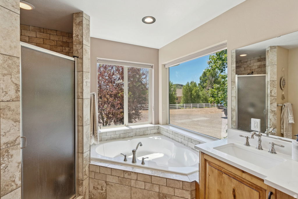 Full bath with a stall shower, vanity, a bath, and recessed lighting