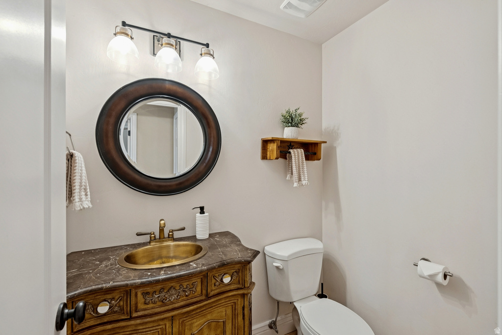 Half bathroom featuring vanity and toilet