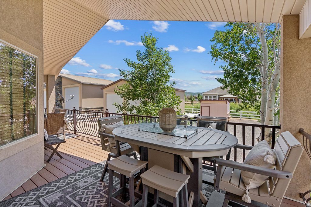 View of wooden balcony with outdoor dining area and a wooden deck
