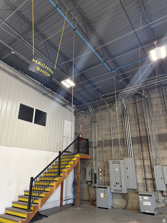 Garage with electric panel, metal wall, and concrete block wall