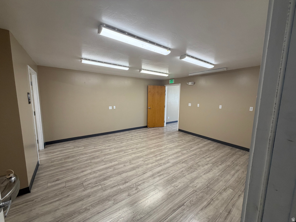 Spare room featuring light wood-style floors and baseboards