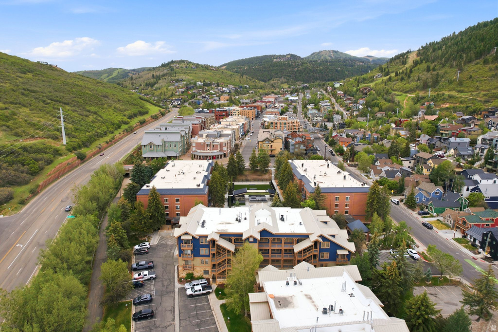 Aerial perspective showcasing multiple residential and commercial buildings nestled among lush green hills