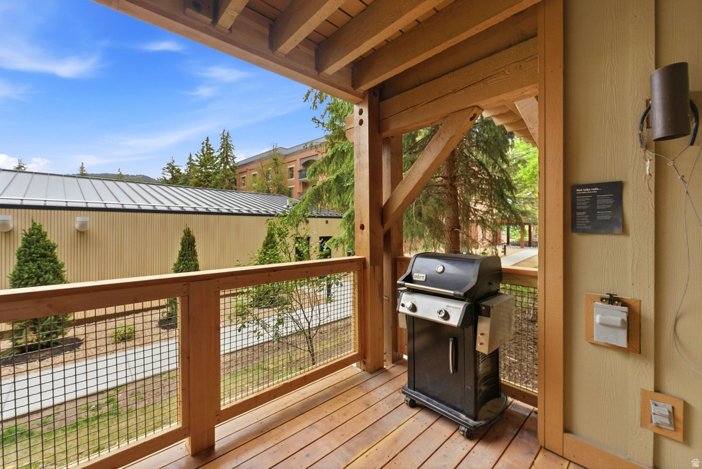 Covered outdoor deck with natural wood flooring and exposed wood ceiling beams