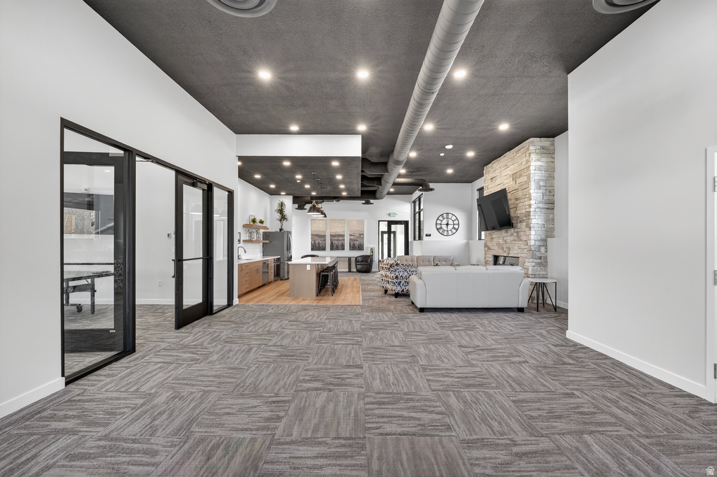 Living room featuring a fireplace, light colored carpet, french doors, and recessed lighting