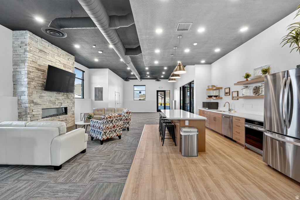Kitchen with open shelves, a kitchen island, open floor plan, a kitchen bar, and stainless steel appliances