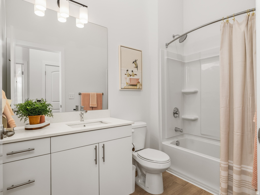 Bathroom with vanity, shower / bath combination with curtain, and light wood-type flooring