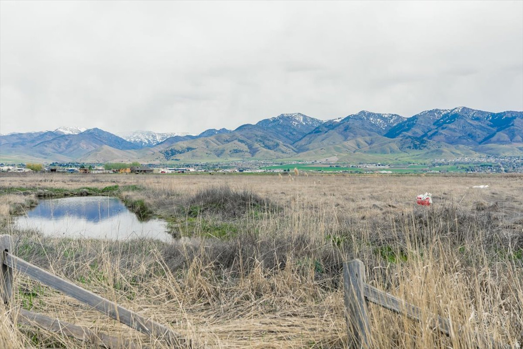 View of mountain background featuring a large body of water and rural landscape