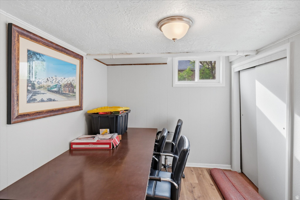 Office with light wood finished floors and a textured ceiling