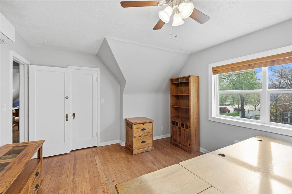 Bedroom featuring vaulted ceiling, light wood finished floors, and a ceiling fan