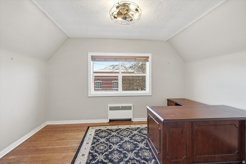 Office space with dark wood-type flooring and radiator