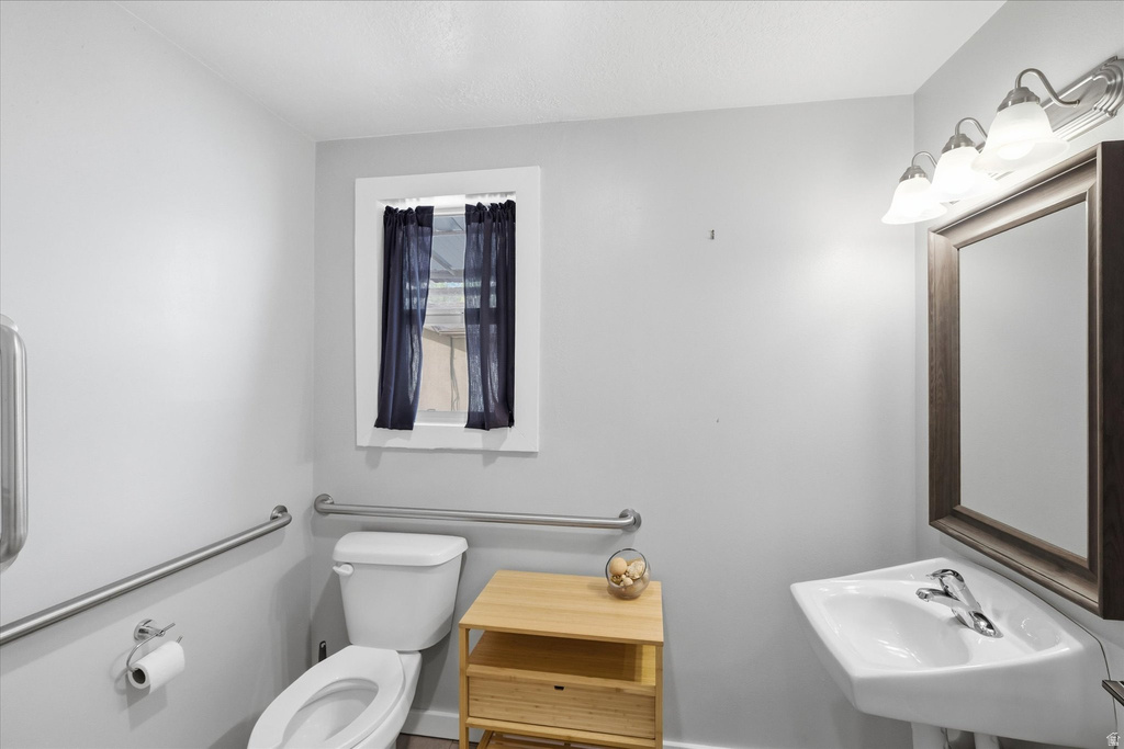 Half bath featuring toilet and a sink