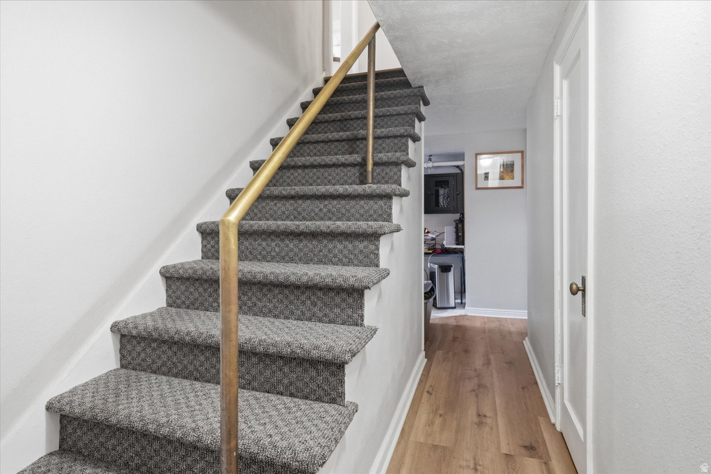 Staircase featuring wood finished floors and baseboards