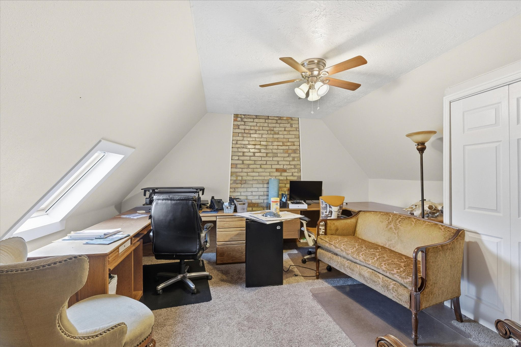Office area with carpet flooring, lofted ceiling, and a ceiling fan