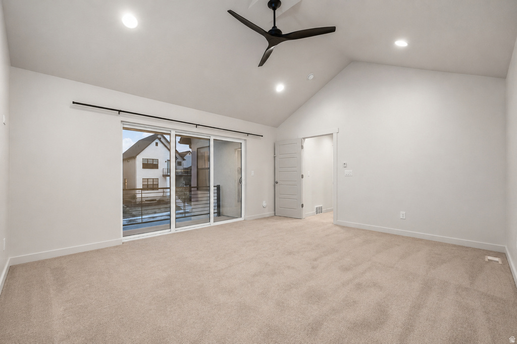 Spacious room featuring vaulted ceilings, recessed lighting, and a modern ceiling fan