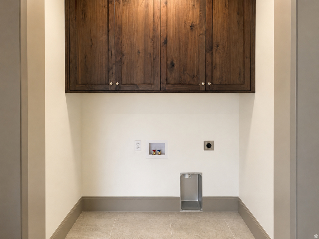 Integrated dark wood-finish cabinetry, light tile flooring, and utility hookups