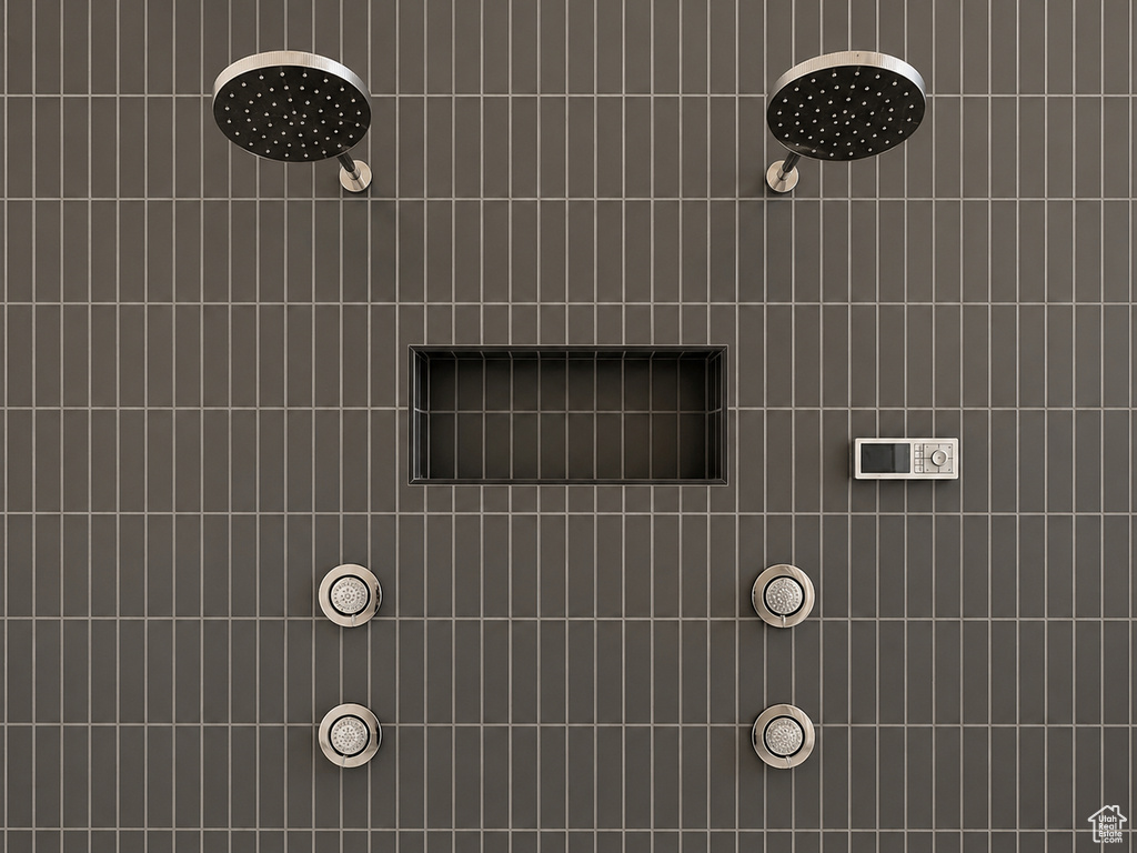 Vertically-stacked tile wall featuring dual rain shower heads, built-in shower niche, and digital control panel with integrated body sprays