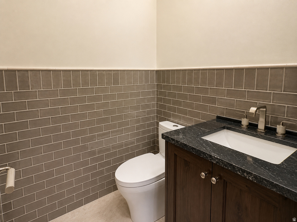 Dark wood-finish vanity with an undermount sink, dark stone countertop, and a brushed nickel faucet