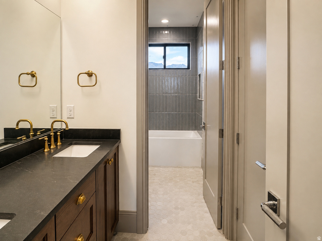 Dual sink vanity with dark countertop and brass fixtures