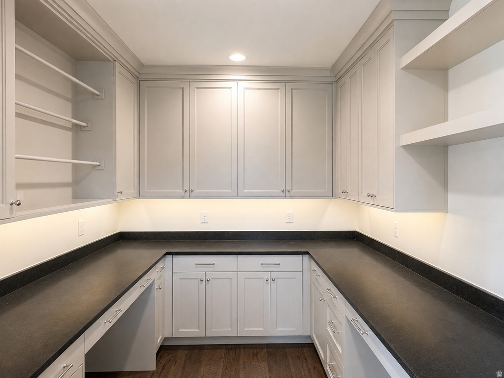 Extensive U-shaped dark stone-finish countertops with light gray cabinetry