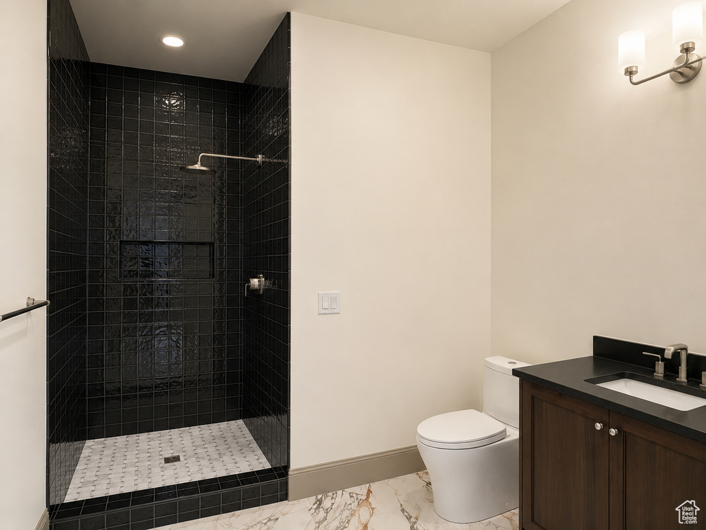 Walk-in shower with dark tile surround and recessed niche, rainfall showerhead, and patterned tile floor