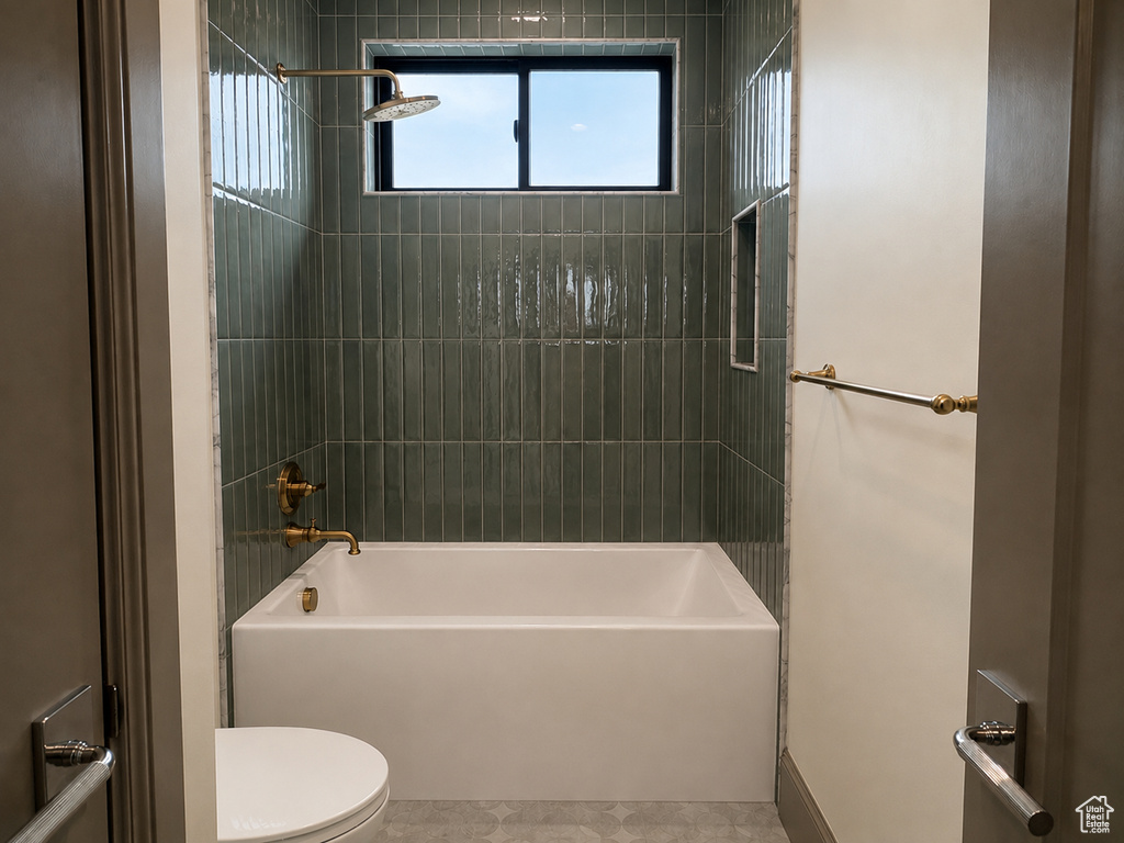 Bathtub with full-height green subway tile surround, integrated shower niche, and a window