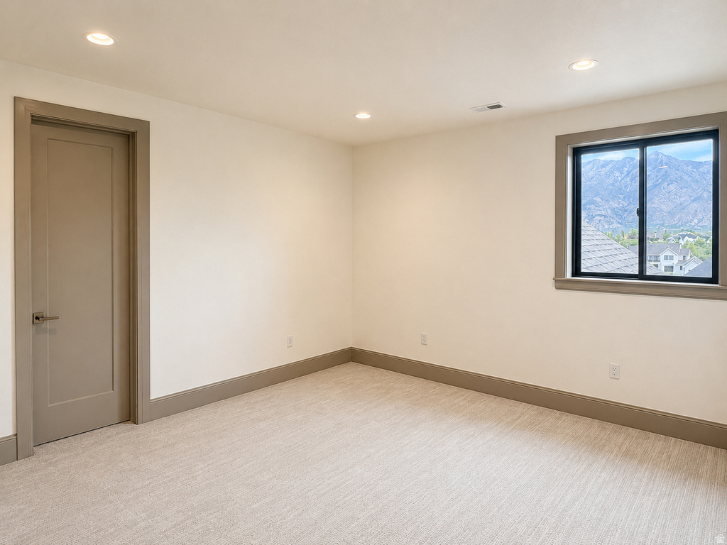 Recessed lighting, neutral-toned walls, and soft pile carpeting