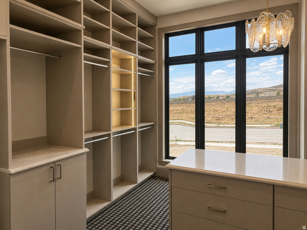 Built-in closet system with varied shelving, hanging rods, integrated lighting, and cabinetry