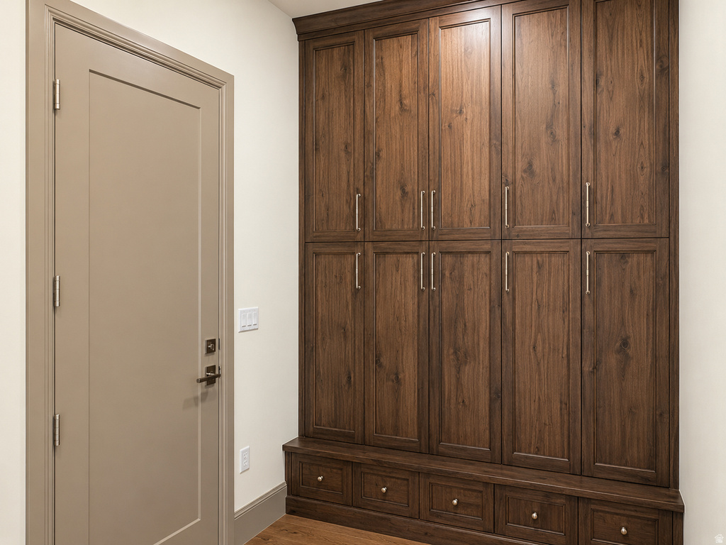 Built-in wood-finish cabinetry featuring multiple storage compartments, a lower bench with integrated drawers, and brushed nickel hardware