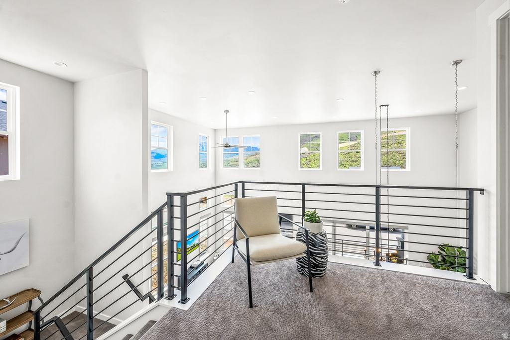 Living area featuring carpet, recessed lighting, and an upstairs landing