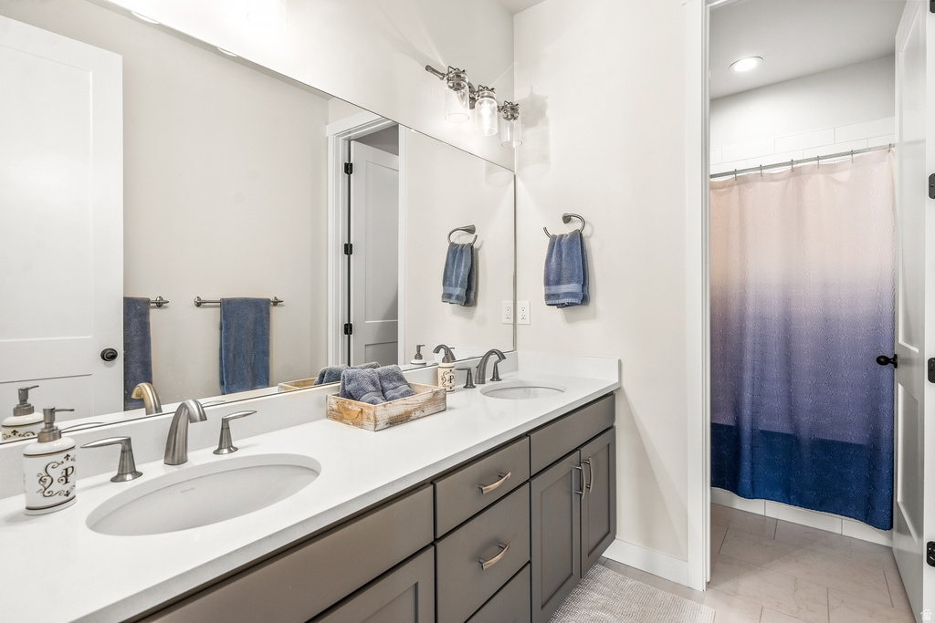 Bathroom with curtained shower and double vanity
