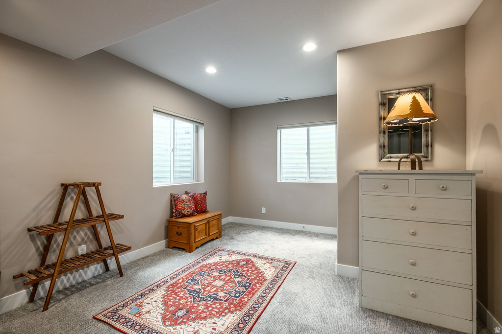 Living area with light colored carpet, healthy amount of natural light, and recessed lighting