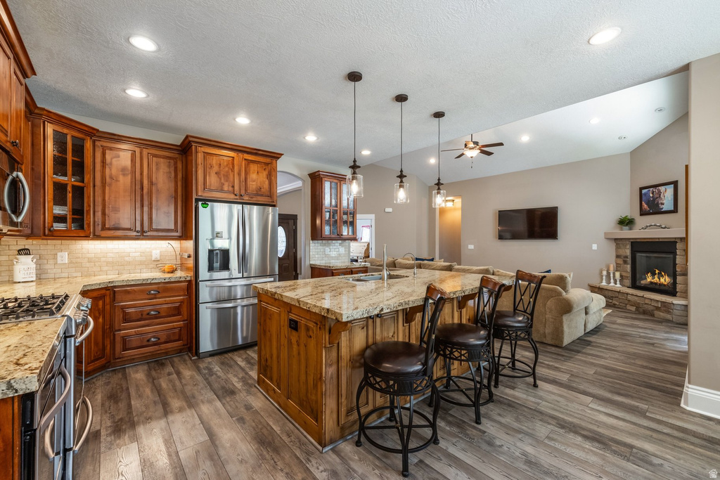Kitchen featuring glass insert cabinets, open floor plan, wood finish cabinetry, and a kitchen breakfast bar