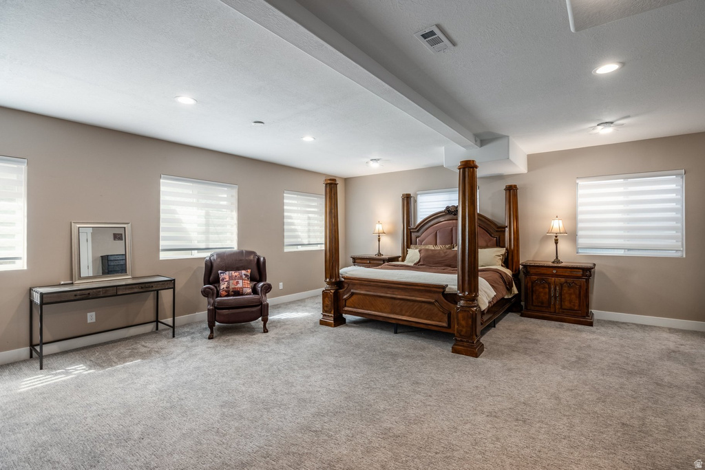 Bedroom with light carpet, multiple windows, and recessed lighting