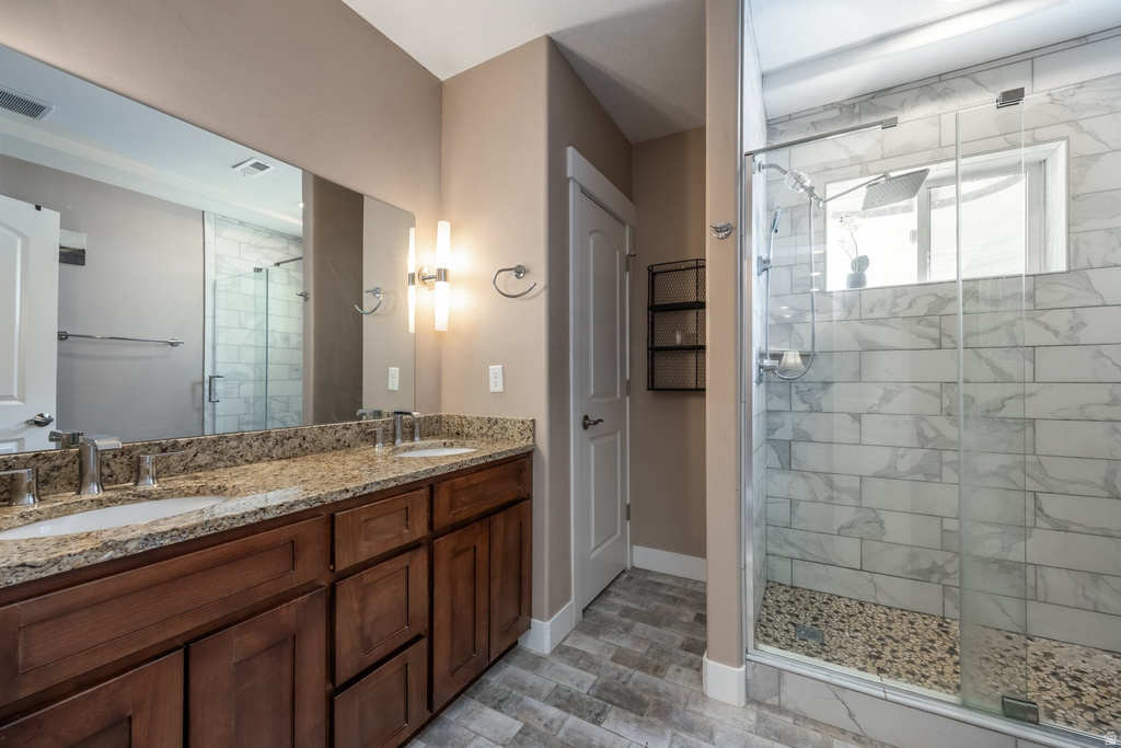 Bathroom featuring double vanity and a stall shower