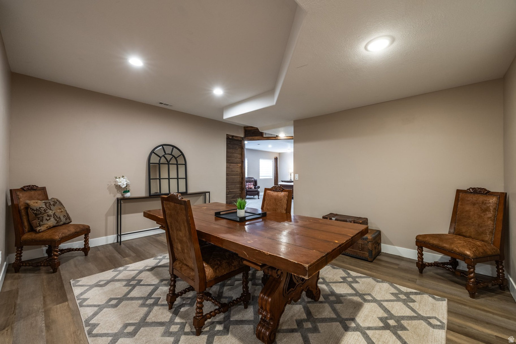 Dining area with light wood-style flooring and recessed lighting