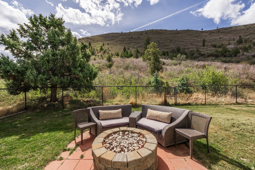 Fenced backyard featuring a patio and an outdoor living space with a fire pit
