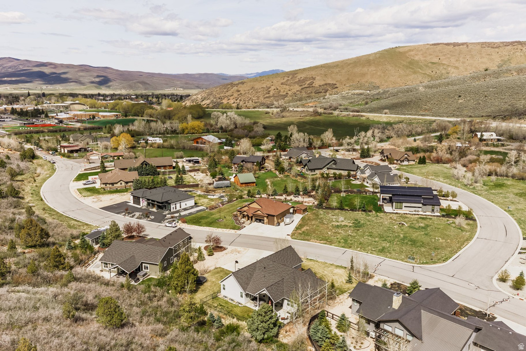 Aerial view of property and surrounding area with a mountain backdrop and nearby suburban area