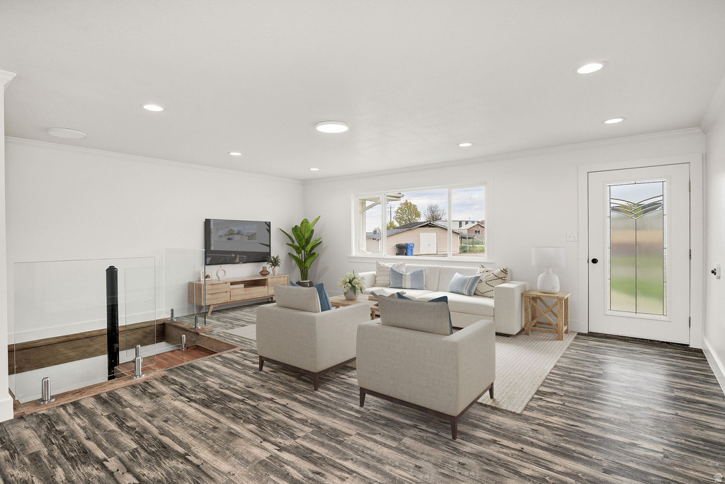 Spacious living area featuring wood-finish flooring, recessed lighting, and a decorative glass-paneled entry door