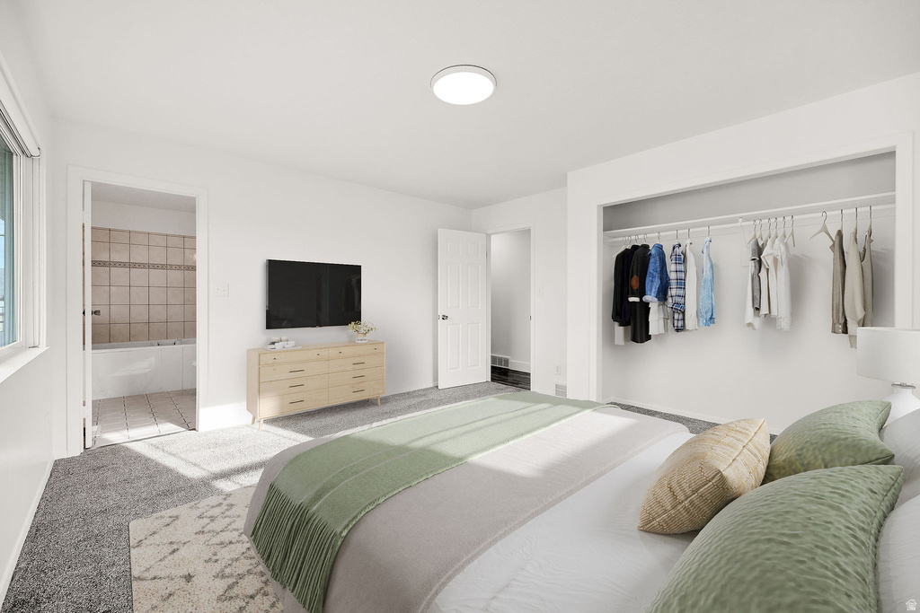 Bedroom featuring plush gray carpeting, a built-in open closet system, and a flush-mount ceiling light fixture