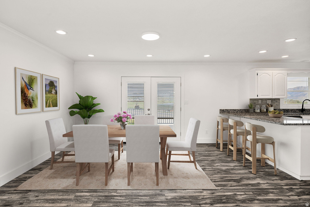 Open-concept dining area featuring wood-finish flooring, recessed lighting, and white trim