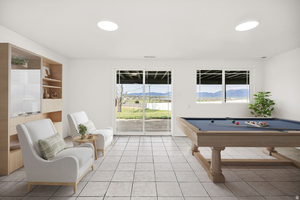 Spacious room featuring light-toned tiled flooring, a built-in shelving unit with glass-fronted cabinets, and recessed ceiling lighting
