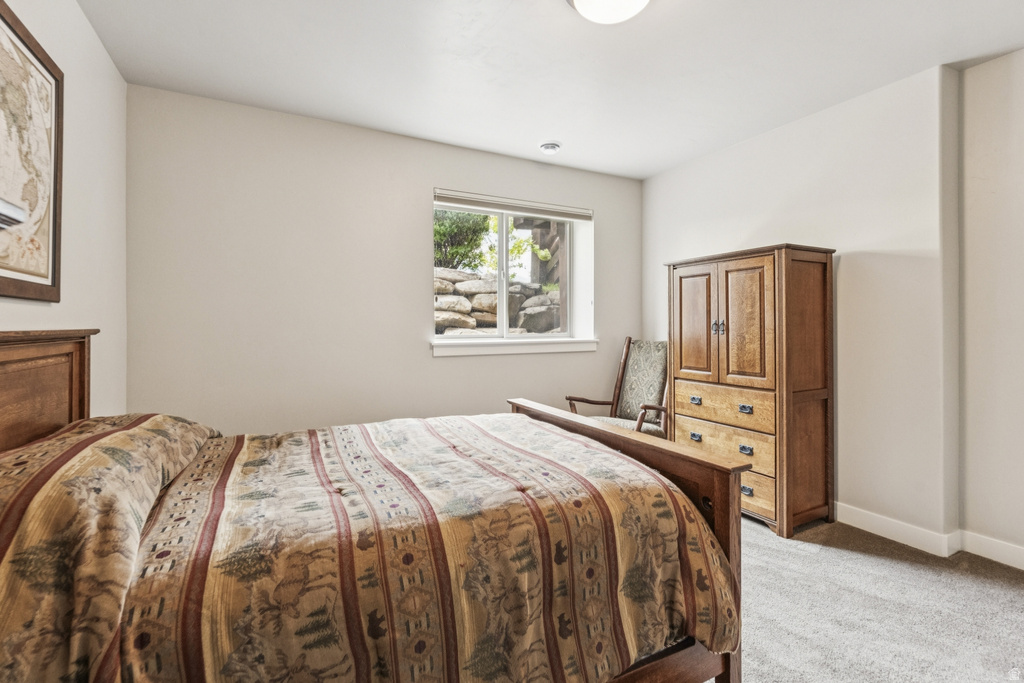 Bedroom featuring light carpet and baseboards