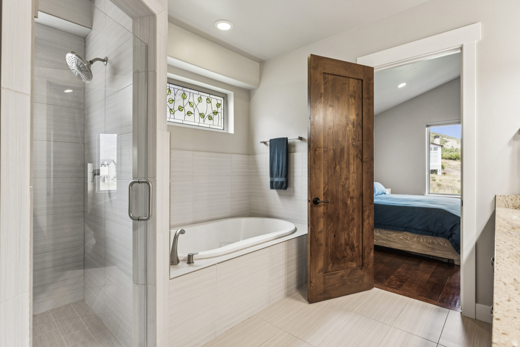 Full bathroom featuring light tile patterned floors, a shower stall, connected bathroom, plenty of natural light, and recessed lighting