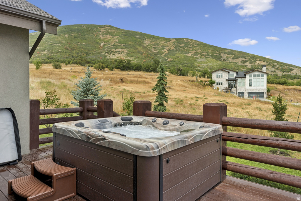 Deck with a mountain view, a view of countryside, and a hot tub
