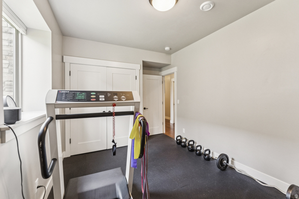 Workout area featuring dark flooring and baseboards