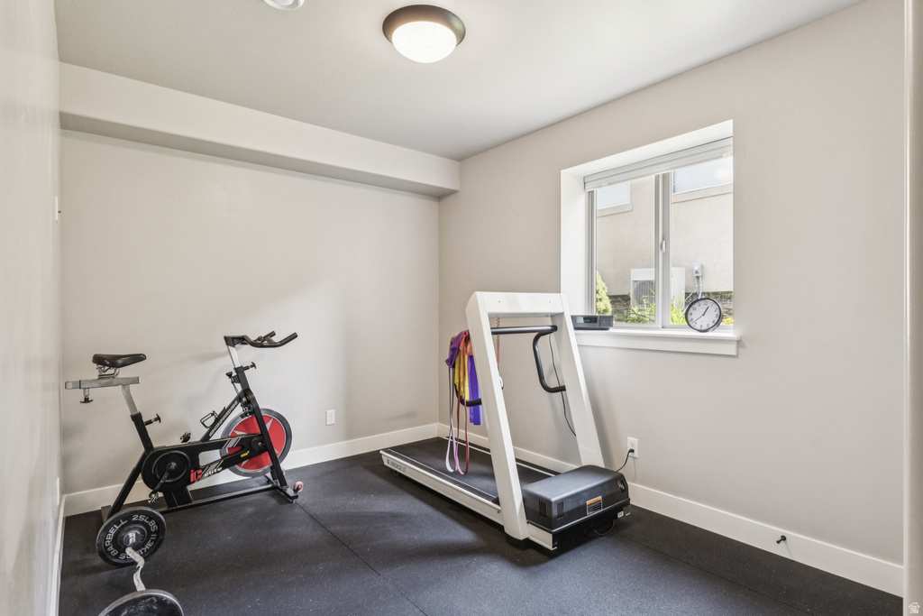 Workout room with baseboards and dark rubber floors