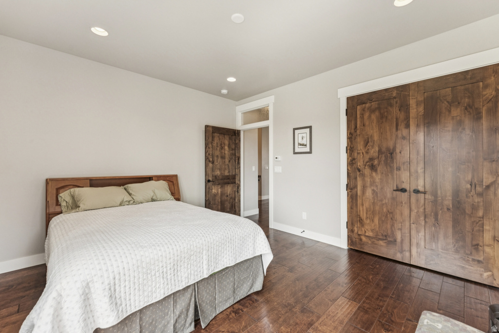 Bedroom featuring dark wood-style floors, a closet, and recessed lighting
