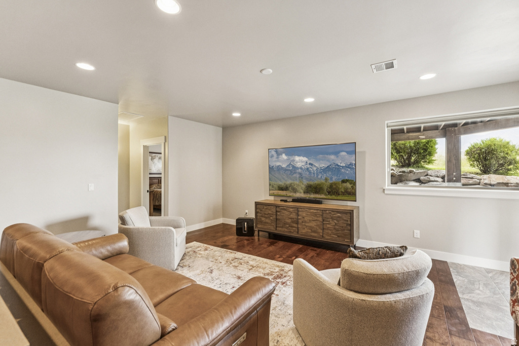 Living room with dark wood-type flooring and recessed lighting