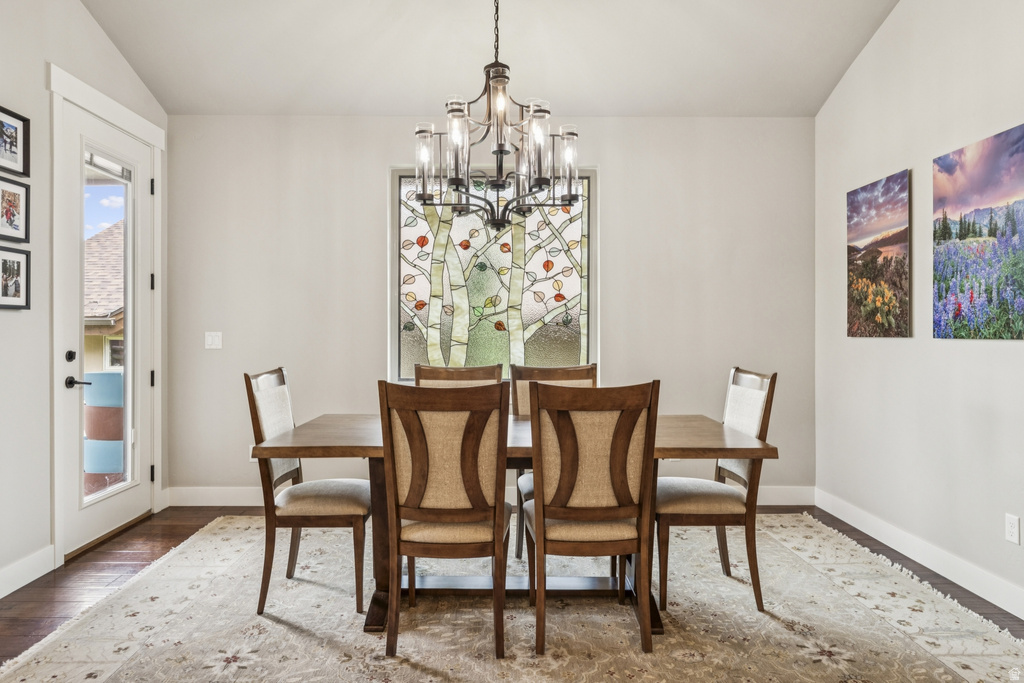 Dining room featuring wood-type flooring, lofted ceiling, and hanging lights