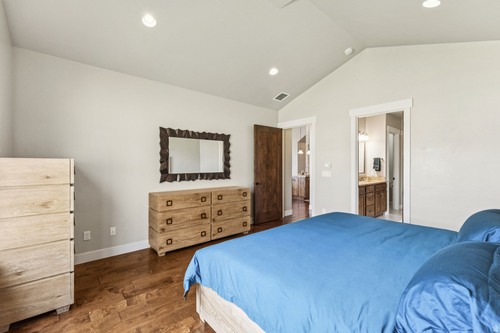 Bedroom with dark wood finished floors, recessed lighting, and ensuite bathroom